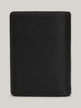 Billetera plegable Tommy Hilfiger de cuero negro con sutil acabado granulado. Presenta costuras distintivas en rojo, blanco y azul en el frente y logo de la marca en la parte inferior.