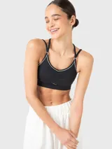 Top deportivo negro con breteles finos ajustables que se cruzan en la espalda, con sutil fruncido en el centro del busto y ribete blanco.