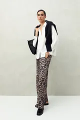 Camisa negra de manga larga con cuello clásico y botones frontales. El tejido presenta una textura arrugada o plisada, y los puños tienen un detalle fruncido o elástico.