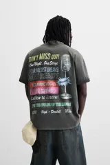 Camiseta negra con efecto lavado, cuello redondo, manga corta y estampado en el frente con la frase "Don't miss out! One Night. One Stage.".
