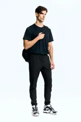 Pantalón de jogging deportivo negro de corte ajustado, confeccionado en tejido funcional DryMove™ que absorbe el sudor. Cuenta con cintura elástica con cordón de ajuste, bolsillos laterales, bolsillos con cierre en las piernas y bajos elásticos.