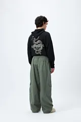 Pantalón cargo color beige, de corte recto y holgado, con cintura elástica y bolsillos laterales con solapa.