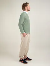 Jersey de punto inglés verde con rayas horizontales blancas, cuello redondo y logo bordado en el pecho.