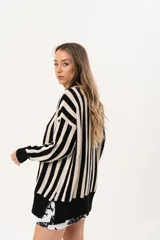 Saco oversize tejido a rayas verticales en blanco y negro, con escote en V y botones.