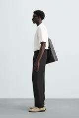 Camiseta verde oscuro de corte holgado, confeccionada en tejido de algodón grueso. Tiene cuello redondo y mangas cortas sin costura en la sisa.