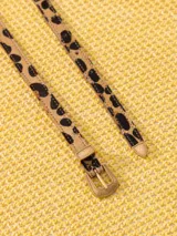 Cinturón delgado de cuero con estampado animal print y hebilla metálica dorada.