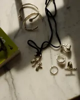 Collar con dije de bronce macizo con forma orgánica o de coral, suspendido de un hilo de seda natural color naranja.