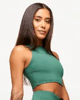 Top deportivo blanco de corte cropped, con cuello alto y logo estampado en el frente.