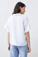 Blusa blanca con escote en V y mangas cortas con volados.