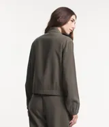 Campera bomber negra de viscosa con cierre delantero, bolsillos con solapa y pespuntes contrastantes en color blanco.