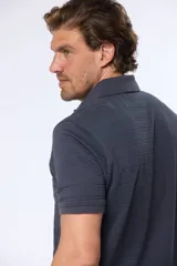 Chomba azul de piqué con cuello clásico, tapeta de dos botones y mangas cortas.