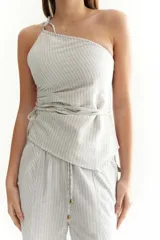 Top de lino a rayas grises y blancas, con un solo bretel y lazo en la cintura.