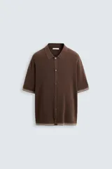 Camisa marrón de punto con viscosa, corte relaxed fit, cuello solapa, manga corta, rib a contraste y cierre frontal con botones.