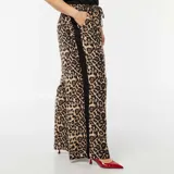 Pantalón ancho con estampado animal print y bandas laterales negras.