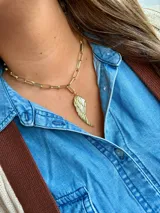 Collar dorado con cadena de eslabones rectangulares y dije en forma de ala.