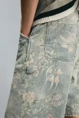 Bermuda de algodón celeste con estampado floral, corte relaxed fit, cinco bolsillos, tira y bolsillo multifunción en la pierna, cierre frontal con cremallera y botón.