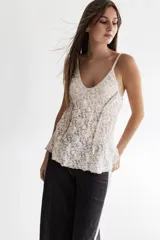 Musculosa de encaje elastizado con motivo de flores, envivada en algodón color gris perla con breteles graduables y detalle de voladitos fruncidos verticales.
