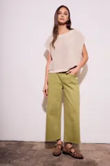 Chaleco de punto calado color beige, con cuello redondo y sisas amplias.