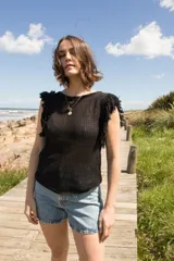 Musculosa de algodón tejida con diseño calado y flecos en los hombros.