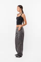 Pantalón gris de cuerina con estampado abstracto, corte recto y tiro medio.
