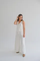 Pantalón palazzo color blanco hueso, de tiro alto y corte holgado. Confeccionado en lino.