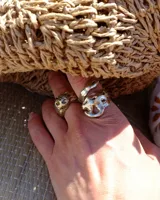 Anillo plateado con forma orgánica irregular, similar a un crustáceo marino.