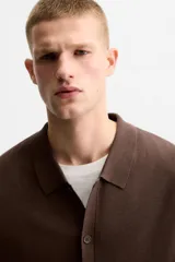 Camisa marrón de punto con viscosa, corte relaxed fit, cuello solapa, manga corta y cierre frontal con botones.