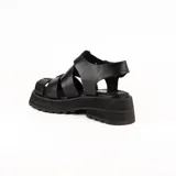 Sandalias negras de cuero con plataforma y tiras anchas entrecruzadas.