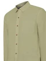 Camisa blanca de manga larga para hombre, confeccionada en algodón orgánico. Cuenta con cuello camisero, cierre con botones de madera, bolsillo en el pecho y mangas ajustables con botones.