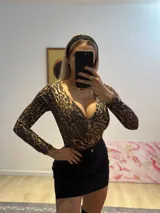 Minifalda negra de bengalina elastizada con bolsillos falsos, cierre y botón metálico.