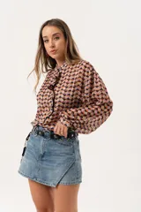 Minifalda de jean azul claro con corte evasé, detalle de short interno y cinturón negro con argollas metálicas.