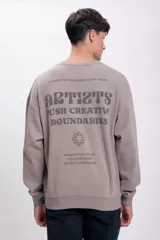 Buzo deportivo color gris topo, de corte holgado y manga larga. Presenta un pequeño estampado en el pecho.