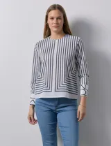 Blusa de gasa estampada a rayas verticales blancas y negras, marca Sioni. Espalda con abertura y botón. Manga larga con puño y botón.