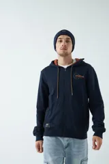 Campera de felpa azul marino con capucha ajustable y cierre frontal. Presenta un logo bordado en el pecho y bolsillos con cierre.