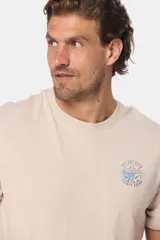 Remera beige de manga corta con cuello redondo y estampado circular en el pecho con la frase "Hit the Road Legacy Brand".