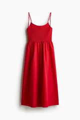 Vestido midi rojo con breteles finos, cuerpo fruncido y falda con vuelo.