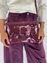 Clutch de lentejuelas de doble cara en tonos grises y plateados, con cierre superior y bordes de cuero.