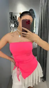 Top strapless fucsia con frunce lateral y corte irregular.