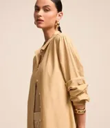 Camisa color beige de viscolino con cuello camisero, manga larga, botonadura frontal y corte holgado.