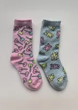 Pack de dos pares de medias de media caña, un par rosa con estampado de chupetines y un par celeste con estampado de ositos de goma.
