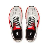 Championes de running On Cloudmonster 2, color blanco con detalles en negro, rojo y rosa.