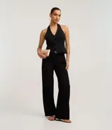 Pantalón de vestir negro de sastrería, corte wide leg y tiro alto. Presenta cierre frontal y trabillas en la cintura, e incluye un cinturón fino de poliuretano.