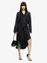 Vestido midi negro de manga larga con cuello camisero y nudo ajustable en la cintura.