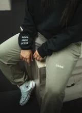 Pantalón de jogging gris melange, corte oversize, con cintura elástica ajustable con cordón y puños ajustados. Estampado en la pierna izquierda con la frase "Just Begin".