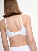 Soutien blanco de microfibra, sin aro ni relleno, con breteles regulables y detalle de costuras en el contorno de las copas.
