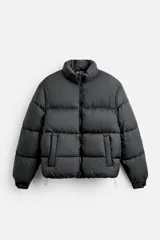 Campera puffer negra con cuello alto, cierre frontal con cremallera, bolsillos laterales y cintura ajustable con cordón elástico.