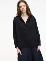 Camisa negra de algodón con botones frontales y cuello camisero.
