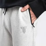 Pantalón de jogging negro, corte relajado, con cintura elástica ajustable mediante cordón. Presenta bolsillos laterales con cierre y un pequeño logo blanco bordado en el muslo derecho.