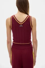 Musculosa tejida color crema con cuello en V y ribete negro.