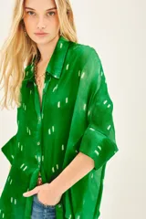 Camisa de seda estampada con diseño batik en tonos azules y blancos, corte amplio y mangas al codo.